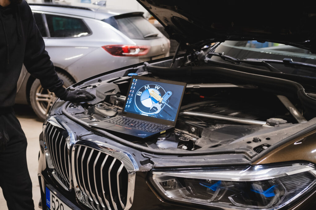 BMW diagnostika Carzone autoteeninduses – arvutiga veakoodide lugemine ja elektroonika kontroll avatud kapotiga sõidukil.