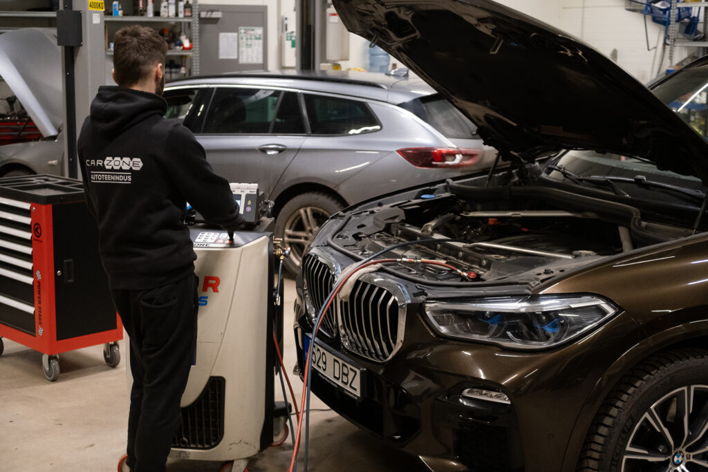 BMW kliima täitmine Carzone autokeskuses – mehaanik ühendab kliimaseadme hooldustööks.