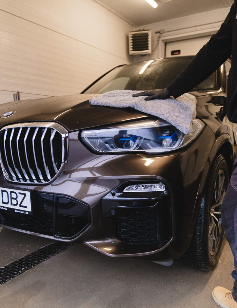 BMW maasturi käsipesu Carzone autokeskuses – sõiduki kuivatamine mikrofiiberlapiga pärast pesu.