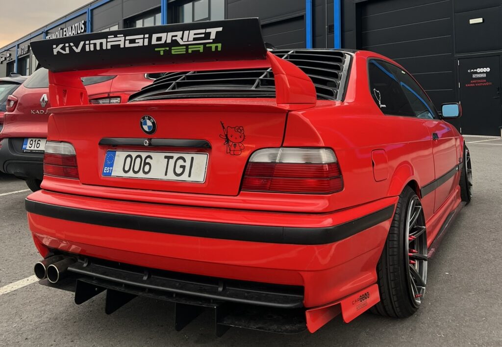 Punane BMW sportauto suure tagatiivaga Carzone autokeskuse ees.