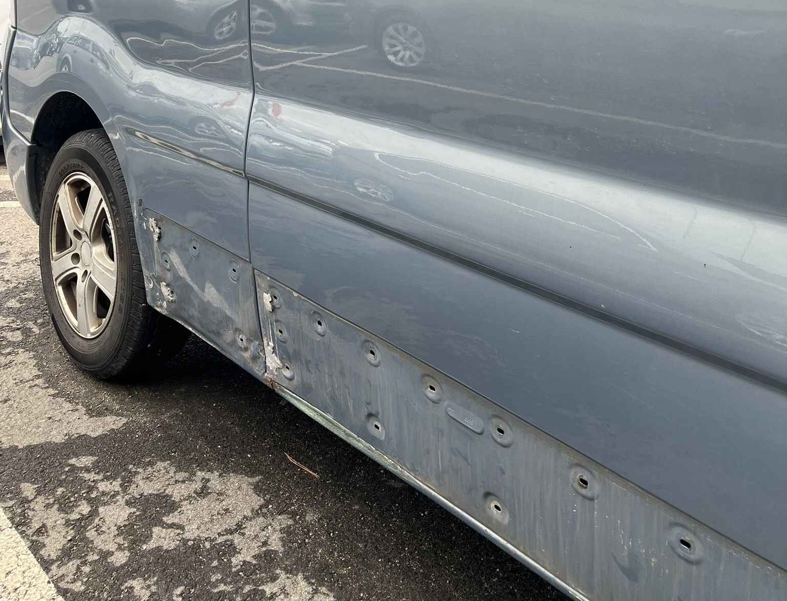 Auto küljekarbi kahjustus ja eemaldatud liist – ettevalmistus pleki- ja värvitöödeks Carzone autokeskuses Tallinnas.